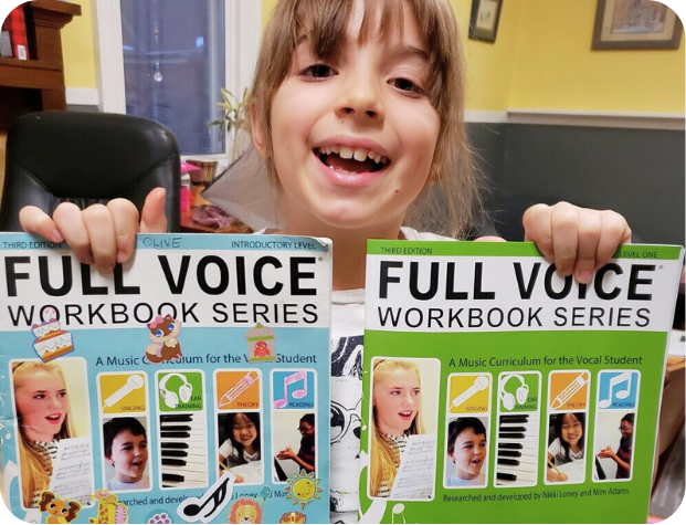 a kid holding Introductory Level covered with stickers and a fresh Level One